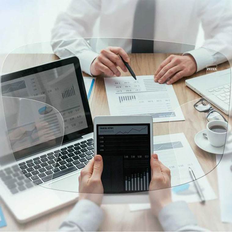 A blurred picture of an office desk & equipments with a lense in the center showing a the office desk in a clear view