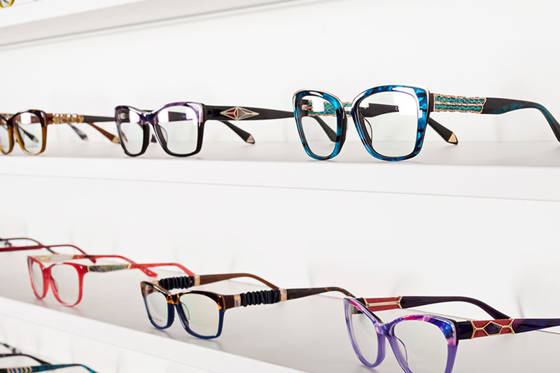 A range of opticians glasses displayed on white shelves
